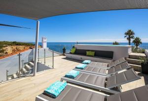 uma varanda com cadeiras e vista para o oceano em Villa Benagil with stunning views and roof terrace with private heated pool em Lagoa