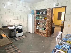 een keuken met een witte koelkast en een fornuis bij Casa do SOL in Guarapari