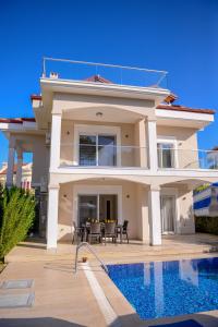 a large house with a swimming pool in front of it at Villa Calıs 2 in Fethiye