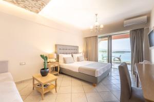 Schlafzimmer mit einem Bett und Meerblick in der Unterkunft Balcony Boutique Hotel in Planos