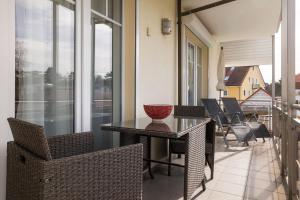 a balcony with a table and chairs on a balcony at Dünenrose in Baabe