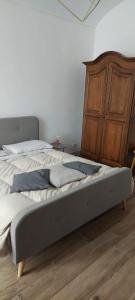 - une chambre avec un grand lit et une commode en bois dans l'établissement GusterHouse, à Ivrea
