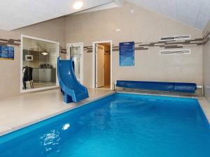 a indoor swimming pool with a slide and a slide at Luxury Retreat with Pool - By Traum Ferienwohnungen in Kongsmark