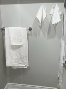 łazienka z białymi ręcznikami wiszącymi na wieszaku w obiekcie Tosam Luxury Lodge Two Bedroom Suite w mieście Brampton