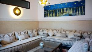 - un salon avec un canapé et un tableau mural dans l'établissement RIAD KALE POLIS, à Marrakech