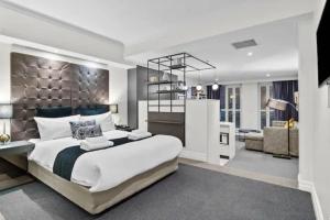 a bedroom with a large bed and a living room at Studio In Prime CBD Location in Sydney