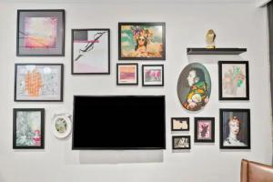 a flat screen tv hanging on a wall with pictures at Studio In Prime CBD Location in Sydney