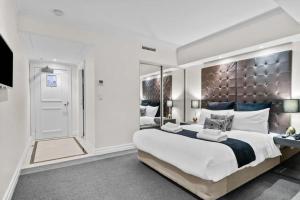 a bedroom with a large bed with a large headboard at Studio In Prime CBD Location in Sydney