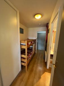 a hallway with a room with wooden floors and a door at Studio avec magnifique vue montagne - Praloup 1500 in Uvernet-Fours