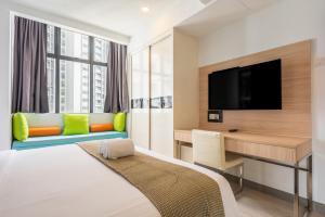 ゲンティンハイランドにあるGenting Grandeur Suite - Ion D'elemenのベッドと机とテレビがあるホテルの部屋