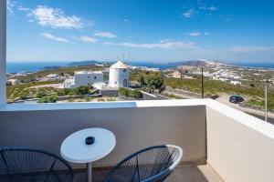 balcón con 2 sillas, mesa y vistas en Orizontes Hotel Santorini, en Pirgos