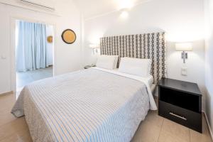 a hotel room with a bed and a television at Orizontes Hotel Santorini in Pirgos
