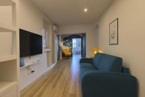 a living room with a blue couch and a television at Torregalli- Terrace Apartment in Florence