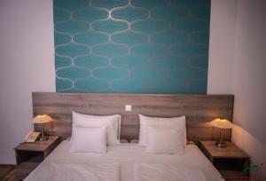 1 dormitorio con 1 cama con sábanas blancas y 2 lámparas en Selfness Hotel Vadvirág Mátraszentimre en Mátraszentimre