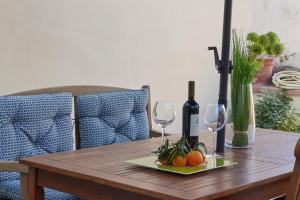 uma mesa de madeira com dois copos de vinho e fruta em Torregalli- Terrace Apartment em Florença