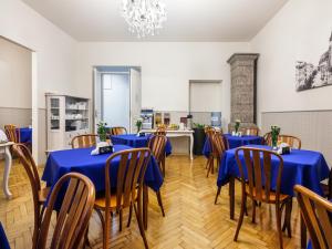 jadalnia z niebieskimi stołami i drewnianymi krzesłami w obiekcie Kosmopolita Apartments w Krakowie