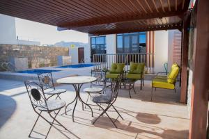 une terrasse avec des chaises et des tables, ainsi qu'une piscine. dans l'établissement AYLOL-أيلول, à Qurayyah