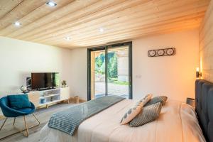 a bedroom with a bed and a tv and a chair at Chalet Frantz'y in Saint-Jean-d'Aulps