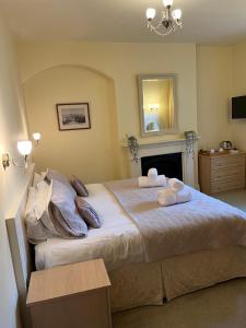 um quarto com uma cama grande e toalhas em Oronsay Guest House em Alnwick