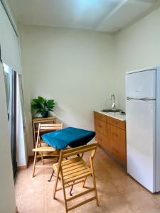 a kitchen with a refrigerator and a table and chairs at houses&halfhouses historic street in Caminha