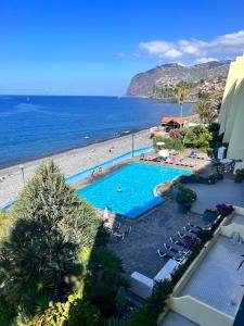un complexe avec une piscine et une plage dans l'établissement Atlantic Gardens Beach - atlanticgardensbeach com, à Funchal