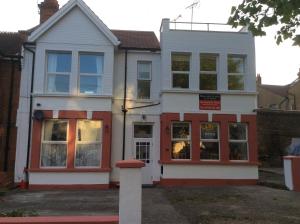 een wit en rood huis met een raam bij Malvern Lodge Guest House- Close to Beach, Train Station & Southend Airport in Southend-on-Sea