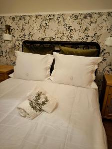 a white bed with white pillows and a plant on it at Casa do Limoeiro in Golegã
