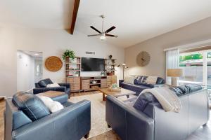 Una sala de estar con dos sofás azules y un televisor. en Desert Casa Del Sol, en Mesa
