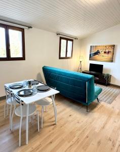 ein Wohnzimmer mit einem blauen Sofa und einem Tisch in der Unterkunft LE DUPLEX BELLE VUE - Hyper Centre in Mont-de-Marsan