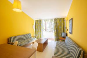- un salon avec deux canapés et une table dans l'établissement Vibra Blanc Cottage Apartmentos - 3SUP, à Sa Caleta