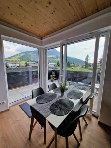 ein Esszimmer mit einem Tisch und Stühlen sowie einem großen Fenster in der Unterkunft Appartement Lurger in Kirchberg in Tirol