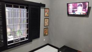 a living room with a tv and a window at CIDERES HOLIDAY HOME in Majalengka