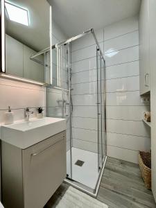 a bathroom with a glass shower and a sink at Piccolo Pirano in Piran