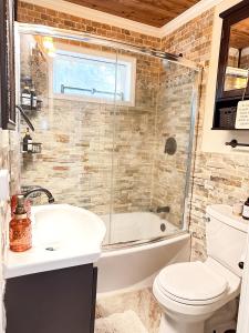 een badkamer met een bad, een toilet en een wastafel bij Cozy Lakeside Fall Escape; Applepick, Hike, Winery in Greenwood Lake