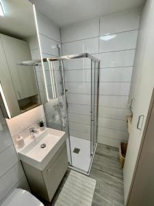 a white bathroom with a shower and a sink at Piccolo Pirano in Piran