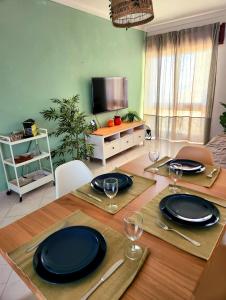a dining room with a table with plates and wine glasses at OceanView Side in Quarteira