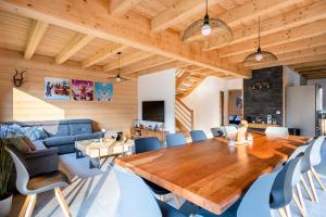 a dining room with a wooden table and blue chairs at Chalet Frantz'y in Saint-Jean-d'Aulps