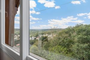 uma janela com vista para uma cidade em VISTA 161 Apto em Gramado com vista espetacular em Gramado