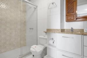 uma casa de banho branca com um WC e um chuveiro em VISTA 161 Apto em Gramado com vista espetacular em Gramado