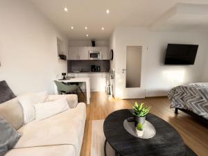 ein Wohnzimmer mit einer Couch und einem Tisch in der Unterkunft Zentrales Apartment für 2 *Bogenstraße* in Norderney + 3 Fotos