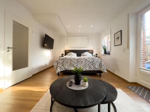 ein Schlafzimmer mit einem Bett und einem Tisch davor in der Unterkunft Zentrales Apartment für 2 *Bogenstraße* in Norderney