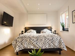 Schlafzimmer mit einem Bett mit einer schwarzen und weißen Bettdecke in der Unterkunft Zentrales Apartment für 2 *Bogenstraße* in Norderney