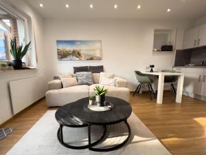 ein Wohnzimmer mit einer Couch und einem Tisch in der Unterkunft Zentrales Apartment für 2 *Bogenstraße* in Norderney