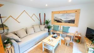 een woonkamer met een bank en een tafel bij Le refuge des myosotis - Savoie proche de Chambéry in Barberaz