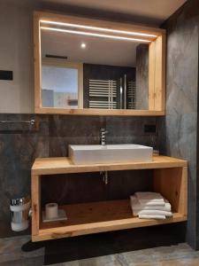 bagno con lavandino e specchio di Hotel del Bosco a Livigno