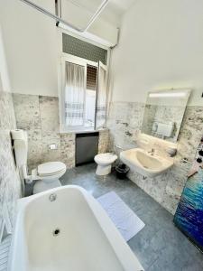 a bathroom with a tub and a toilet and a sink at Bovisa House B&B private rooms in Milan