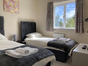 a bedroom with two beds and a window at Newly built 3 Bed House with Ample Parking 2 in Balderton