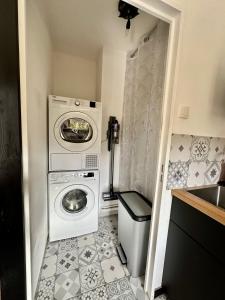 uma pequena casa de banho com uma máquina de lavar roupa e uma máquina de lavar roupa em L'évasion verte em Langres