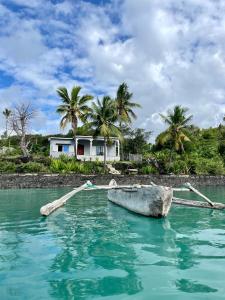Salama Eco-Lodge and Hostel في Mitsamiouli: قارب في الماء امام المنزل