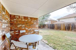 a patio with a table and chairs and a brick wall at Casa Killeen in Killeen
